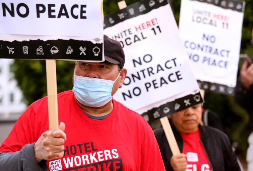 SANTA MONICA, CA - JULY 12, 2023 - Jose Ayala, 66, left, walks the picket line with fellow Unite Here Local 11 hotel workers in front of the Viceroy Hotel in Santa Monica on July 12, 2023. Ayala works as a dishwasher for the Viceroy Hotel and has to work a second job to make ends meet. Some older hotel workers scrape by on their income and can't afford to quit. Some work two jobs just to make ends meet. Unite Here Local 11 hotel employees have been striking for higher pay and better benefits. (Genaro Molina/Los Angeles Times)