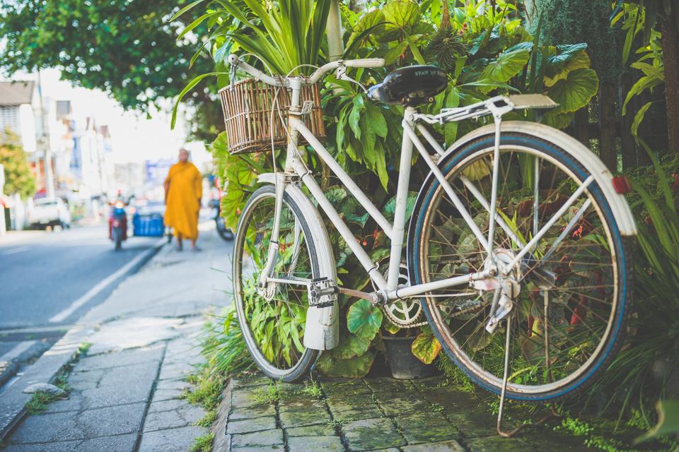 An old white bicycle parked on the street in Chiang Mai in Thailand