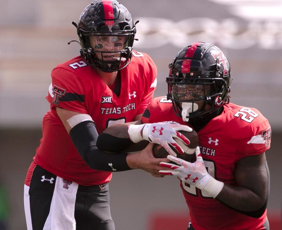 Texas Tech quarterback Behren Morton (2) hands off to running back Tahj Brooks (28) during the Red Raiders' 49-28 victory Saturday against Houston at Jones AT&T Stadium. Morton threw for 161 yards and two touchdowns, and Brooks ran for 106 yards and two TDs.