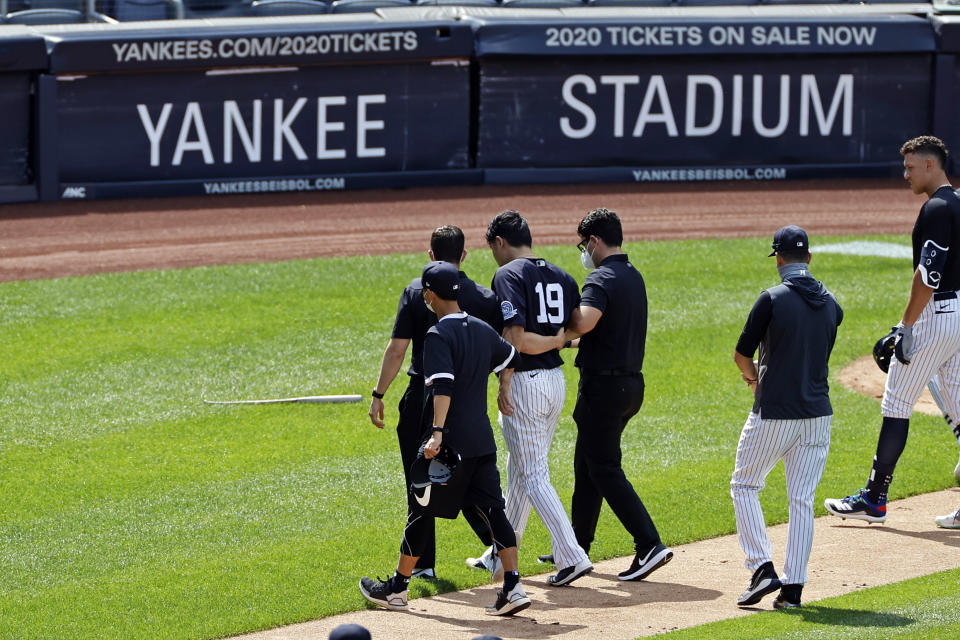 New York Yankees pitcher Masahiro Tanaka (19) is helped off the field by team medical personnel after being hit by a ball off the bat of Yankees Giancarlo Stanton during a baseball a workout at Yankee Stadium in New York, Saturday, July 4, 2020. (AP Photo/Adam Hunger)