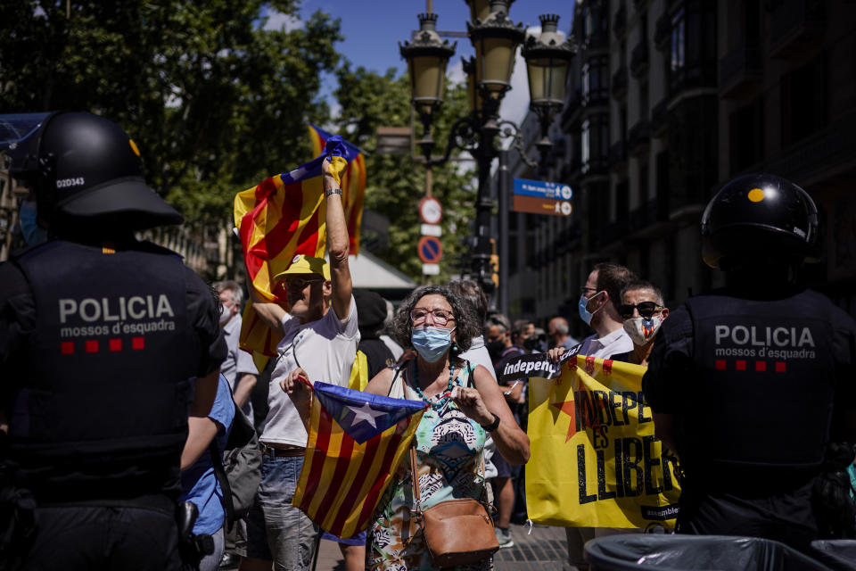 Demonstrators hold "esteladas" or Catalan pro-independence flags during a protest against Spain's prime minister Pedro Sanchez outside the Gran Teatre del Liceu in Barcelona, Spain, Monday, June 21, 2021. Sanchez's said Monday that the Spanish Cabinet will approve pardons for nine separatist Catalan politicians and activists imprisoned for their roles in the 2017 push to break away from Spain. (AP Photo/Joan Mateu)