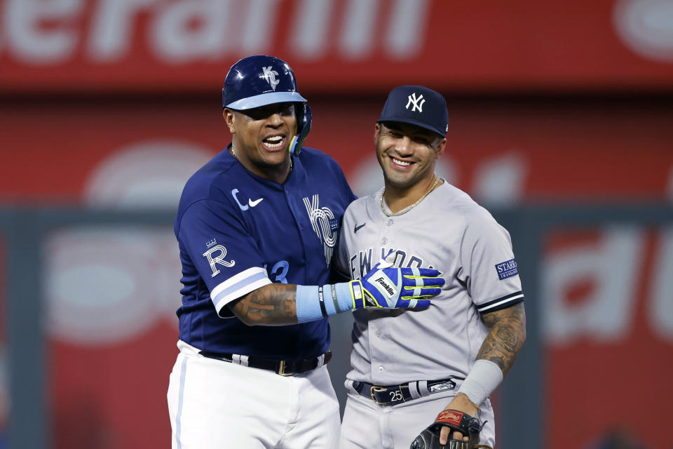 Kansas City Royals' Salvador Perez (13) laughs with New York Yankees second baseman Gleyber Torres after hitting a two-run double during the first inning of a baseball game in Kansas City, Mo., Friday, Sept. 29, 2023. (AP Photo/Colin E. Braley)