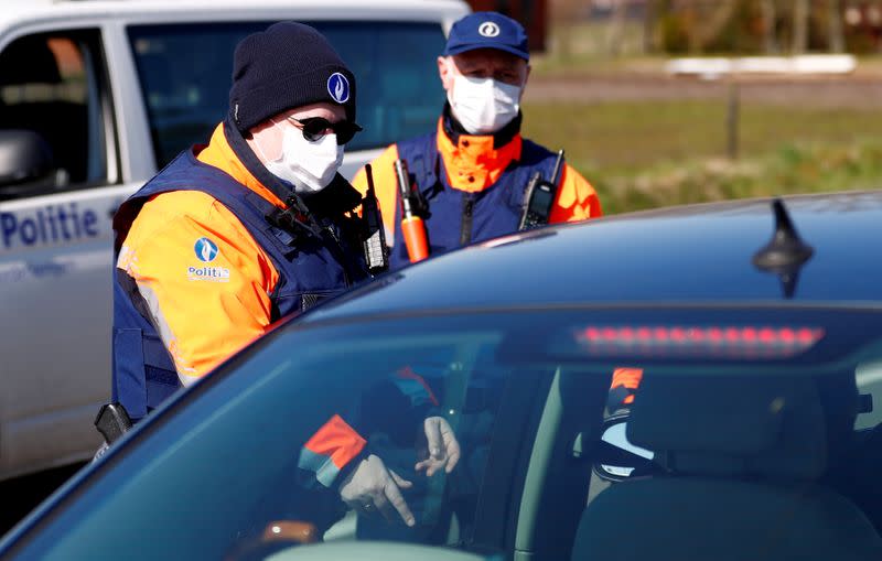 FILE PHOTO: Belgian police officers wearing a protective mask control a driver on the Belgian-Dutch border in Meersel-Dreef