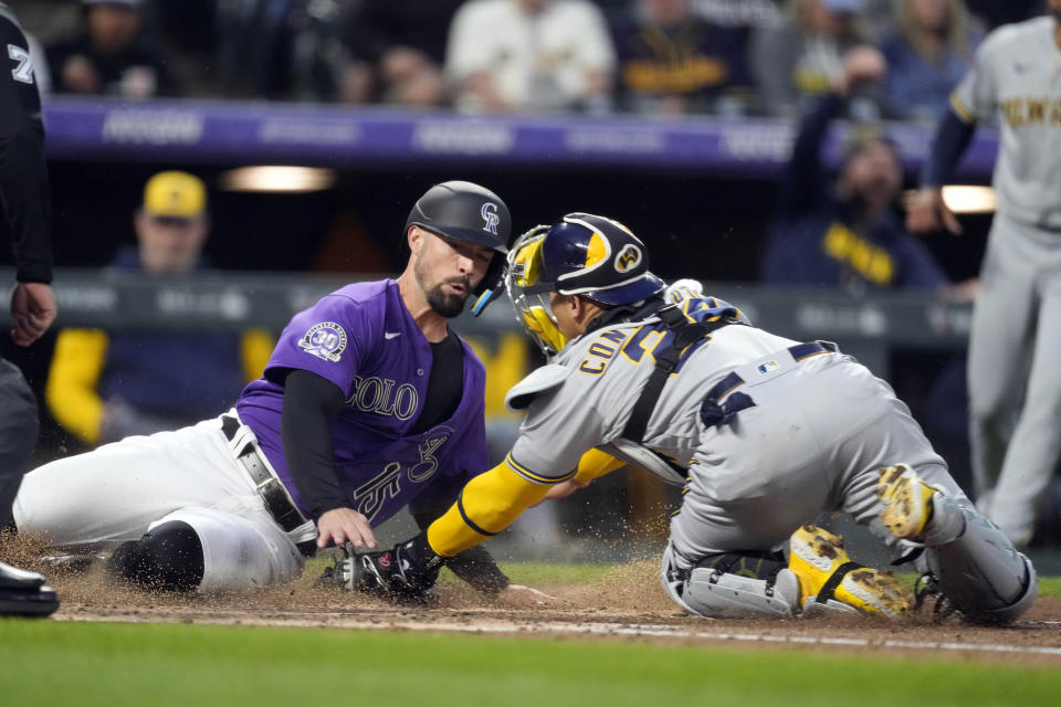 Milwaukee Brewers catcher William Contreras, right, tags out Colorado Rockies' Randal Grichuk as he tries to score on a fly out hit by Ezequiel Tovar in the fourth inning of a baseball game Tuesday, May 2, 2023, in Denver. (AP Photo/David Zalubowski)