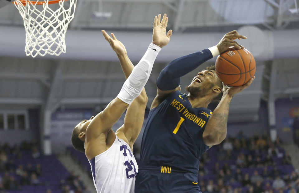 West Virginia forward Derek Culver (1) goes up for a shot as TCU forward Jaedon LeDee (23) defends during the first half of an NCAA college basketball game, Saturday, Feb. 22, 2020 in Fort Worth, Texas. (AP Photo/Ron Jenkins)