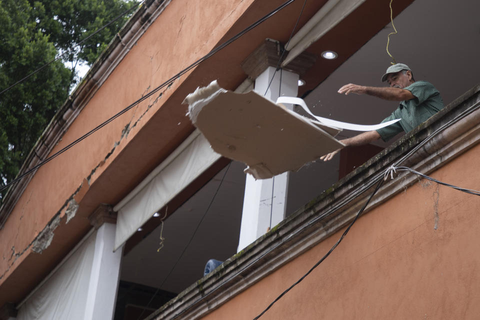 A resident tosses materials from a building damaged by the previous day's earthquake in Coalcoman, Michoacan state, Mexico, Tuesday, Sept. 20, 2022. A magnitude 7.6 earthquake shook Mexico’s central Pacific coast on Monday, killing at least one person. (AP Photo/Armando Solis)