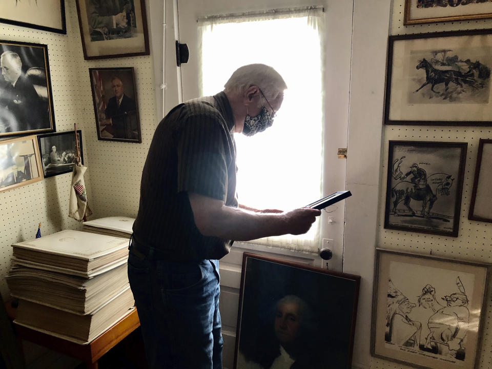 FILE - Gary Hacker, a member of the Johnson County Genealogical and Historical Society reads a personal letter from President Woodrow Wilson to Powell's father, a druggist in Vienna Oct. 8, 2020, at the Paul Powell Home and Museum in Vienna, Ill. For more than half a century, a Powell-established $250,000 trust sustained his legacy, for better or worse. But the account that maintained his birthplace as a museum will soon run dry. (AP Photo/John O'Connor, File)