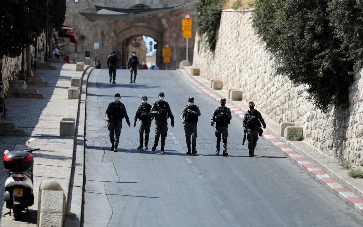 Israeli security forces walk by the entrance to Lions Gate in Jerusalem - Reuters