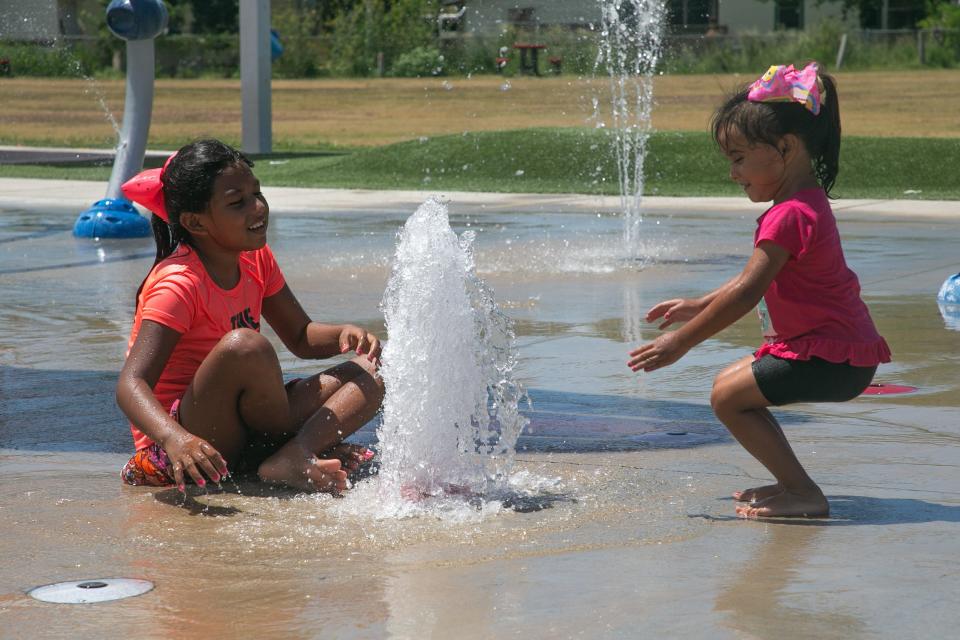 Hazel Hernandez, 8, and Rylee Vicente, 3, enjoy a water spout at the Lindale Park Splash Pad Thursday, July 6, 2023.