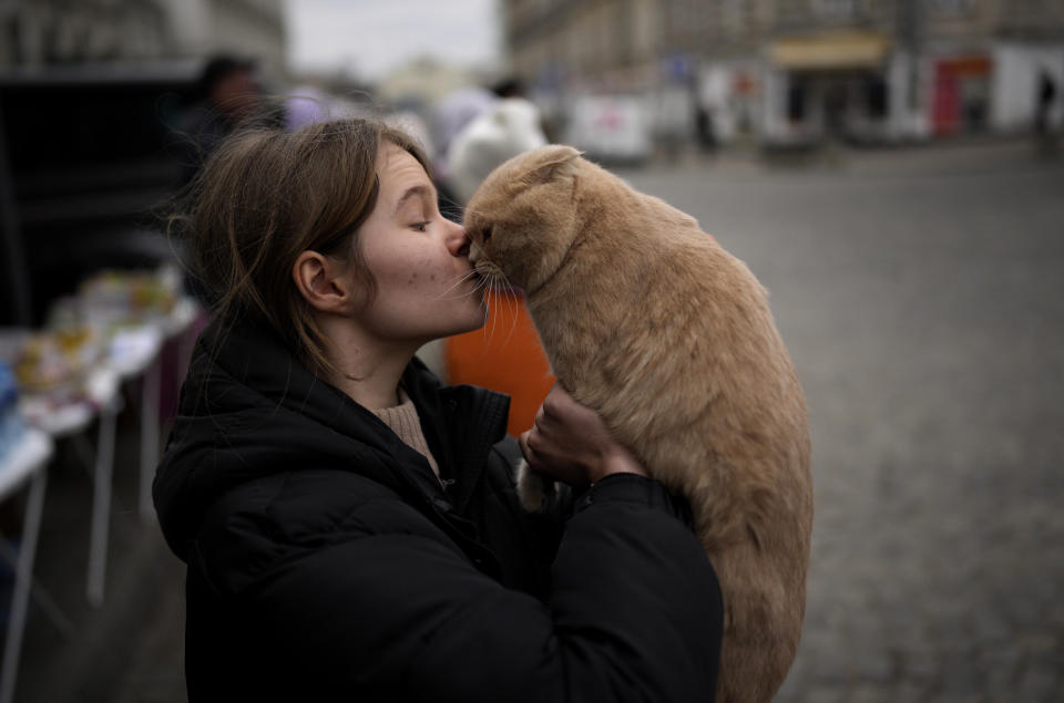 Julia Lazarets plays with her cat Gabriel, after fleeing Ukraine and arriving at the train station in Przemysl, Poland, Tuesday, March 8, 2022. (AP Photo/Daniel Cole)
