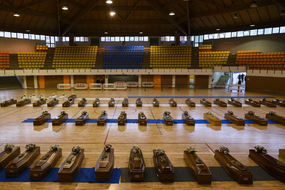 FILE - This Feb. 28, 2023 file photo shows the coffins, aligned inside the PalaMilone sports center in Crotone, southern Italy, of the migrants who died after their boat capsized in the early morning of Sunday, Feb. 26, 2023, at a short distance from the shore in Steccato di Cutro, in the Italian southern tip, killing at least 94 people. The UN migration agency marks a decade since the launch of the Missing Migrants Project, documenting more than 63,000 deaths around the world. More than two-thirds of victims remain unidentified highlighting the size of the crisis and the suffering of families who rarely receive definitive answers. (AP Photo/Valeria Ferraro, File)