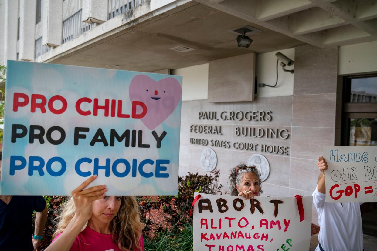 Protesters carry signs and listen to speakers as they demonstrate in front of the Paul G. Rogers Federal Building and U.S. Courthouse on May 3, 2022, in West Palm Beach, Florida. A draft opinion suggests the U.S. Supreme Court could be poised to overturn the landmark 1973 Roe v. Wade case that legalized abortion nationwide.