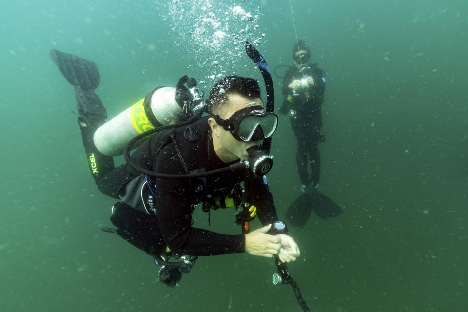 Justin Miyano, left, vessel operations coordinator, and Kimberly Roberson, research coordinator for Gray's Reef National Marine Sanctuary, make a safety stop while scuba diving at the sanctuary Monday, Oct. 28, 2019, off the coast of Savannah, Ga. (AP Photo/David J. Phillip)