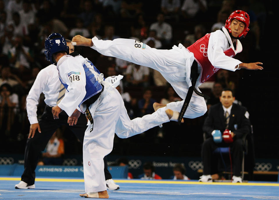 ATHENS - AUGUST 26:  Mu Yen Chu of Chinese Taipei jumps up for a kick against Tamer Bayoumi of Egypt in the men's under 58 kg Taekwondo preliminary match on August 26, 2004 during the Athens 2004 Summer Olympic Games at the Sports Pavilion part of the Faliro Coastal Zone Olympic Complex. (Photo by Al Bello/Getty Images)