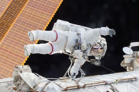 Scott Kelly during a spacewalk in which Kelly and Flight Engineer Tim Kopra successfully moved the International Space Station's mobile transporter rail car ahead of a docking of a Russian cargo supply spacecraft, December 21, 2015. REUTERS/NASA