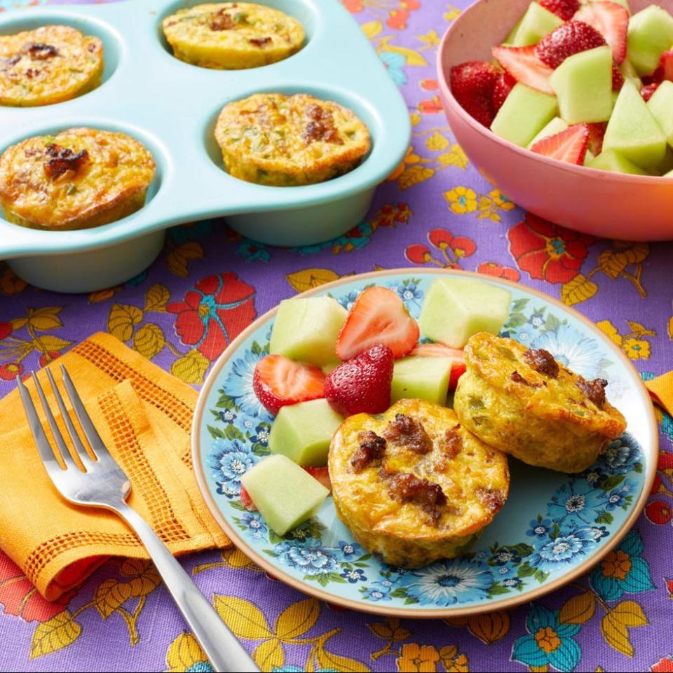 individual sausage casseroles on plate with fruit salad