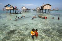 Un grupo de jóvenes juega en el agua, en su barrio en el mar Sulawesi, en la isla de Borneo. Una comunidad de 30 familias de la etnia indígena de gitanos del mar aún <b>mantiene una vida nómada, basada en el mar</b>, y solo acude a tierra a enterrar a sus muertos. (REUTERS/Bazuki Muhammad).