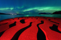 <p>The rusted swirls of the iron sculpture ‘Seven Magic Points’ in Brattebergan, Norway mirror the rippling aurora above. (Rune Engebø)</p>
