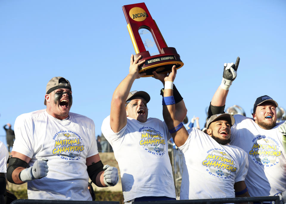 From left to right, South Dakota State's Garret Greenfield, quarterback Mark Gronowski, Jason Freeman and Mason McCormick celebrate with the trophy after their win over Montana at the FCS Championship NCAA college football game Sunday, Jan. 7, 2024, in Frisco, Texas. (AP Photo/Richard W. Rodriguez)