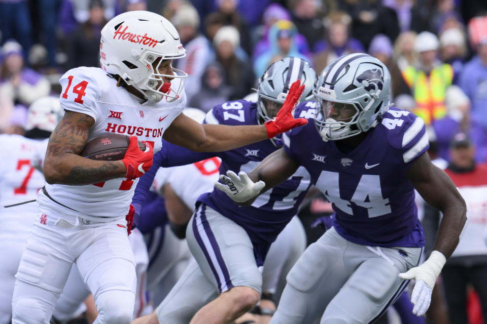 Houston wide receiver Jonah Wilson (14) stiff-arms Kansas State linebacker Tobi Osunsanmi (44) during the second half of an NCAA college football game in Manhattan, Kan., Saturday, Oct. 28, 2023. (AP Photo/Reed Hoffmann)