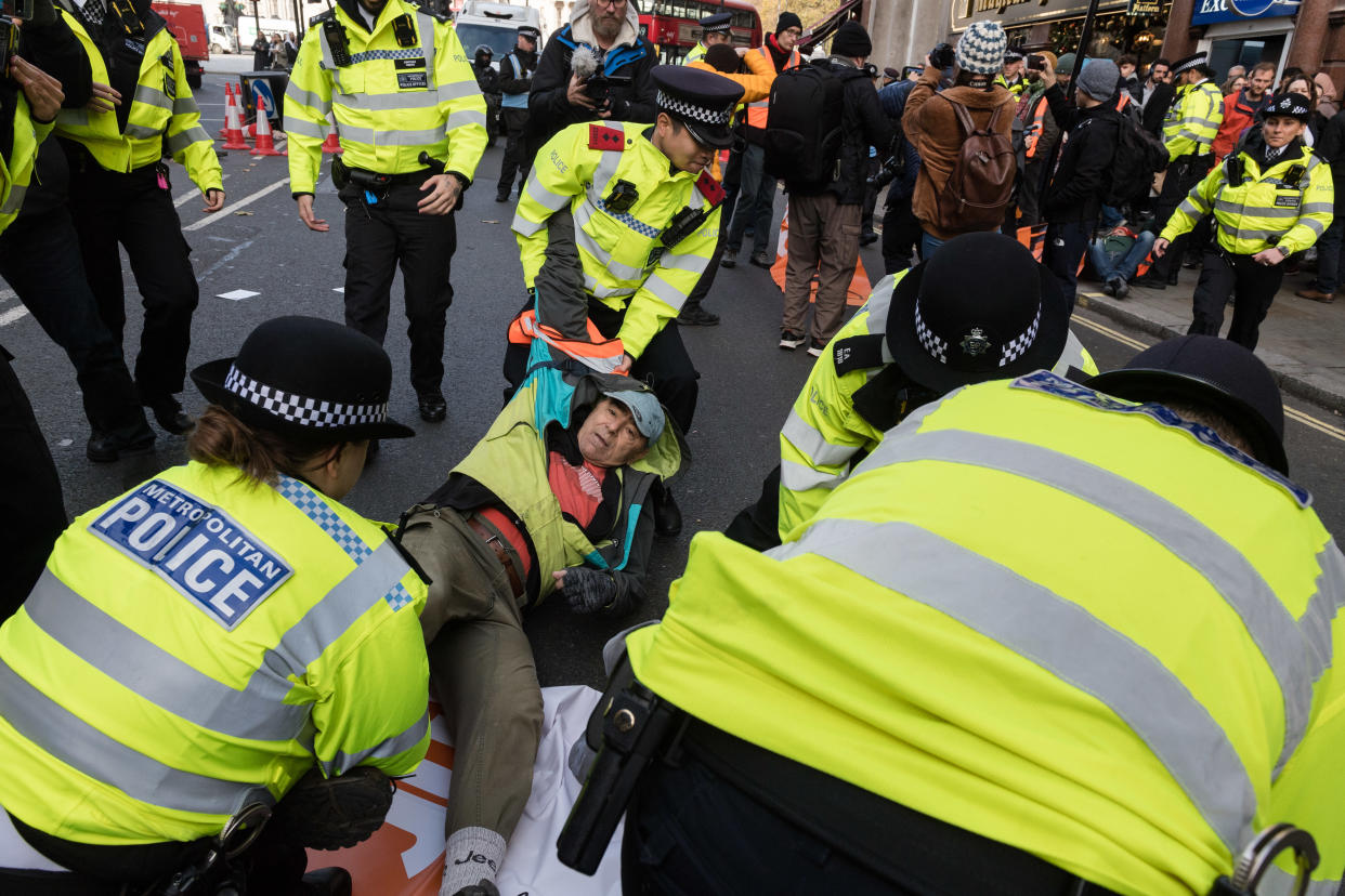 Police officers arrest environmental activists from Just Stop Oil. (Future Publishing via Getty Images)