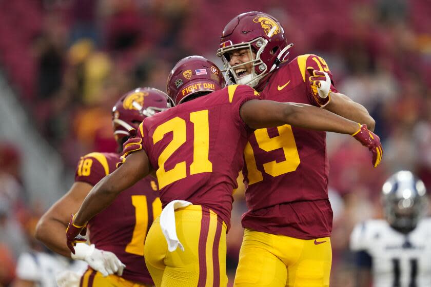 USC running back Quinten Joyner embraces receiver Duce Robinson after Robinson scored a touchdown