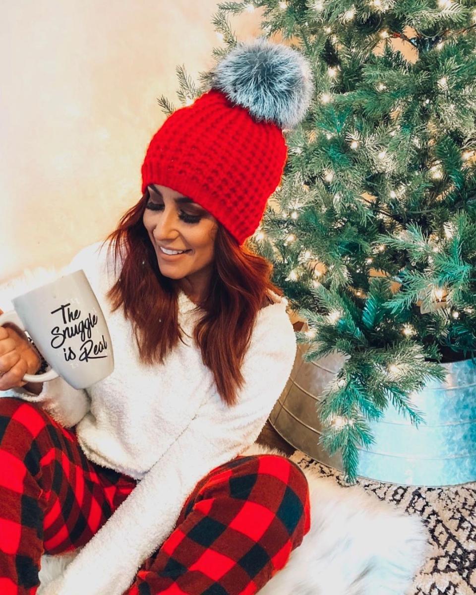 Chelsea Houska smiles near a Christmas tree