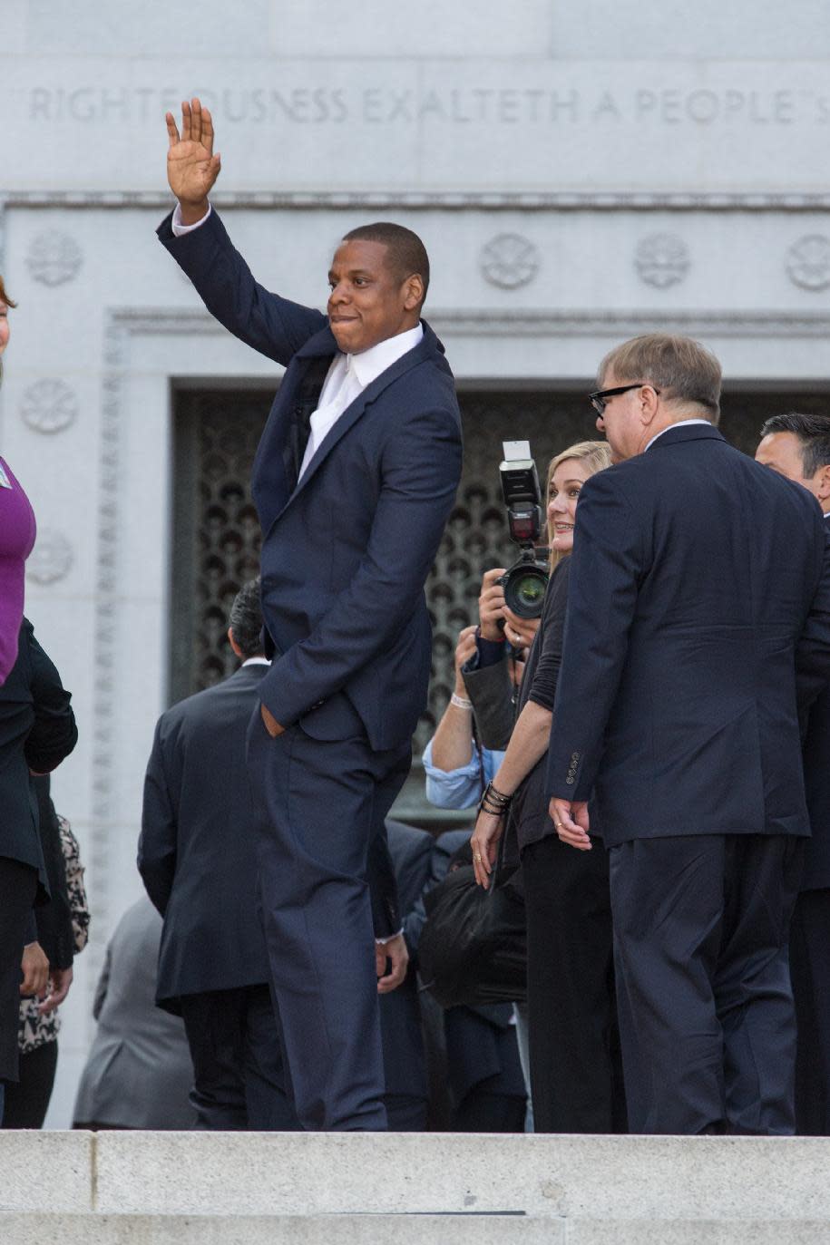 Jay-Z Carter, also known as Shawn carter, waves at a news conference at City Hall on Wednesday, April 16, 2014 in Los Angeles. The music mogul was joined by the city’s mayor Wednesday at Los Angeles City Hall to announce the Made in America music festival, a two-day concert, which is planned for Labor Day weekend. (Photo by Paul A. Hebert/Invision/AP)