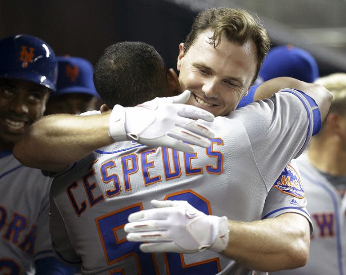 Jay Bruce embraces Yoenis Cespedes after hitting a big two-run home run in a 5-2 win against the Marlins. (AP)