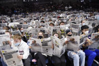 Connecticut students pretend to read the paper as Georgetown players are introduced at the start of an NCAA college basketball game, Tuesday, Jan. 25, 2022, in Storrs, Conn. (AP Photo/Jessica Hill)