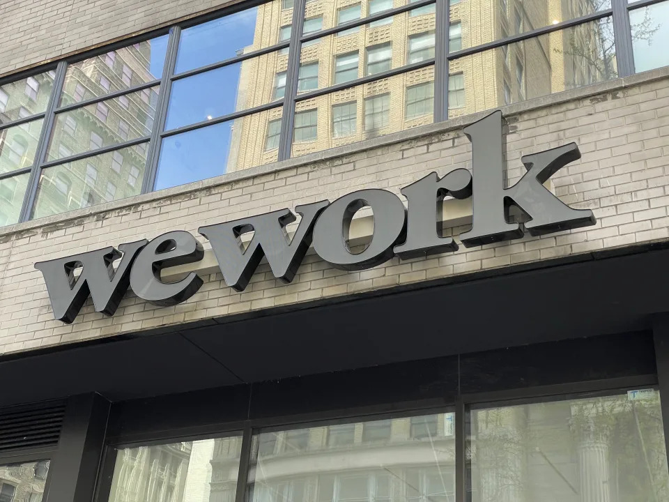 A WeWork logo displayed on the front of a building in the city.