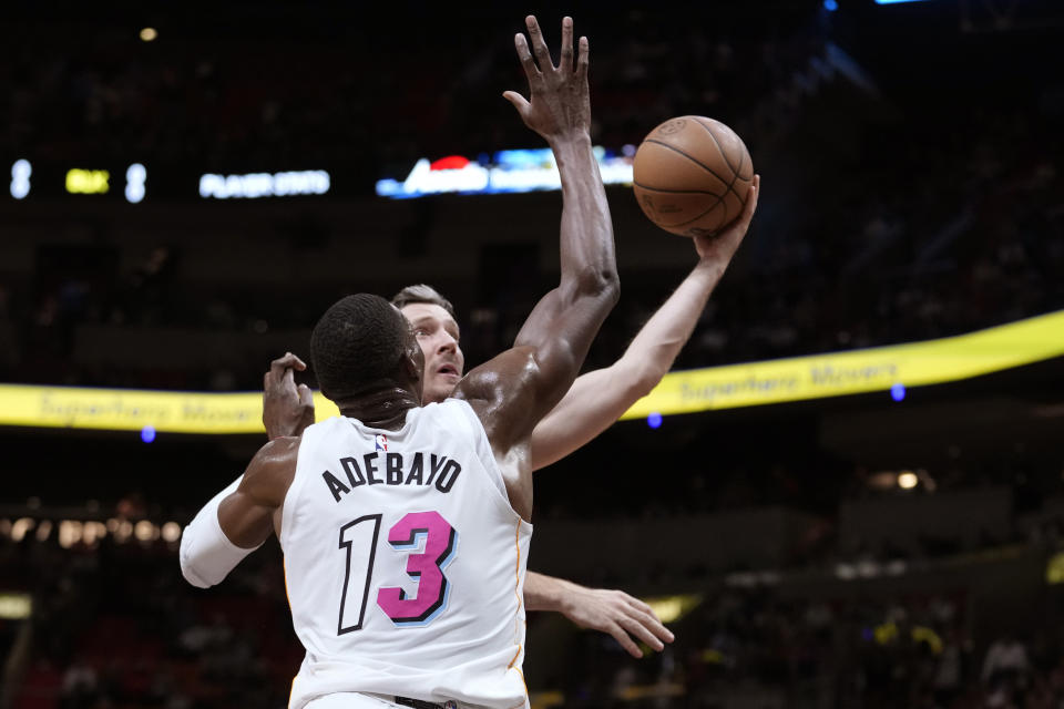 Chicago Bulls guard Goran Dragic, right, shoots as Miami Heat center Bam Adebayo (13) defends during the first half of an NBA basketball game, Tuesday, Dec. 20, 2022, in Miami. (AP Photo/Lynne Sladky)