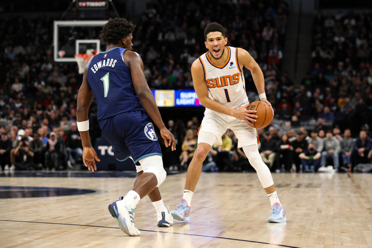Devin Booker #1 of the Phoenix Suns directs traffic while Anthony Edwards #1 of the Minnesota Timberwolves guards him