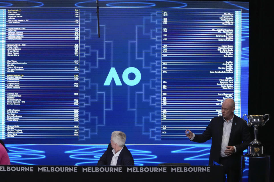 Tournament referee Wayne McKewen, right, and Craig Tiley, tournament chief executive officer, conduct the draw ahead of the Australian Open tennis championships at Melbourne Park, Melbourne, Australia, Thursday, Jan. 11, 2024. (AP Photo/Mark Baker)