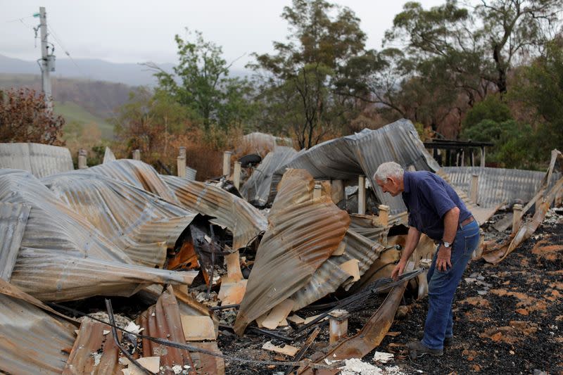 Farmer Jeff McCole, 70, looks through the remains of his family home destroyed by bushfire during an interview with Reuters in Buchan, Victoria, Australia