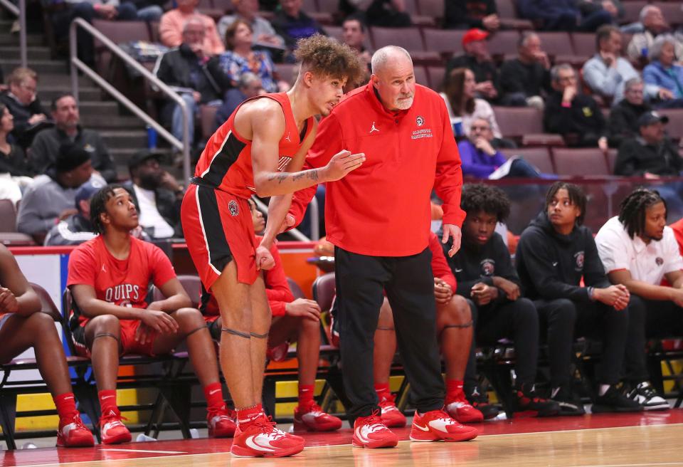 Aliquippa's Donovan Walker (left) talks to head coach Nick Lackovich (right) during the second half of the PIAA 2A Championship game against Lancaster Mennonite Friday afternoon at the Giant Center in Hershey, PA.