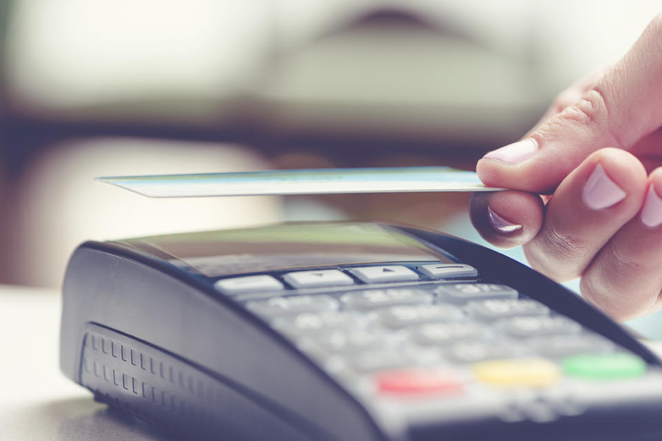 woman's hand scanning credit card at EFTPOS machine