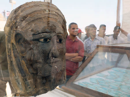 A silver mask gilded with gold seen inside a glass casing at the site of a recently discovered burial shaft near Egypt's Saqqara necropolis, in Giza Egypt July 14, 2018. REUTERS/Mohamed Abd El Ghany