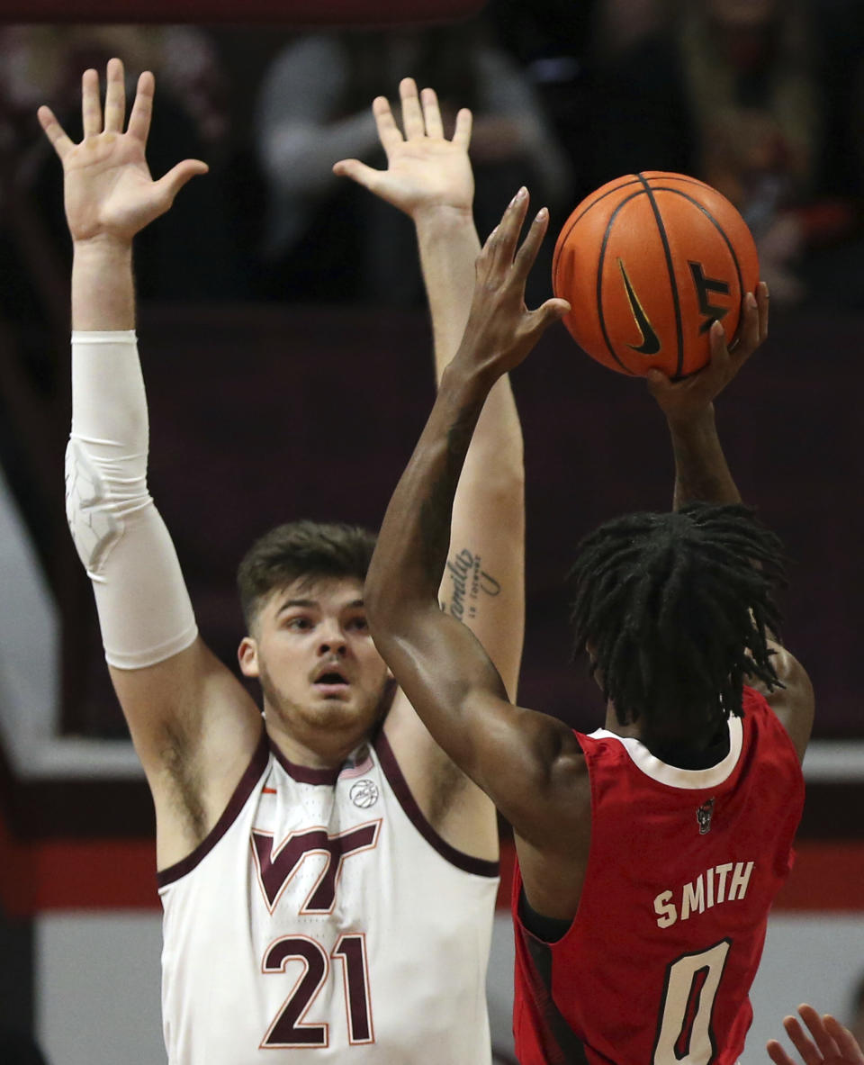 Virginia Tech's Grant Basile (21) defends against North Carolina State's Terquavion Smith (0) during the first half of an NCAA college basketball game Saturday, Jan. 7, 2023, in Blacksburg, Va. (Matt Gentry/The Roanoke Times via AP)