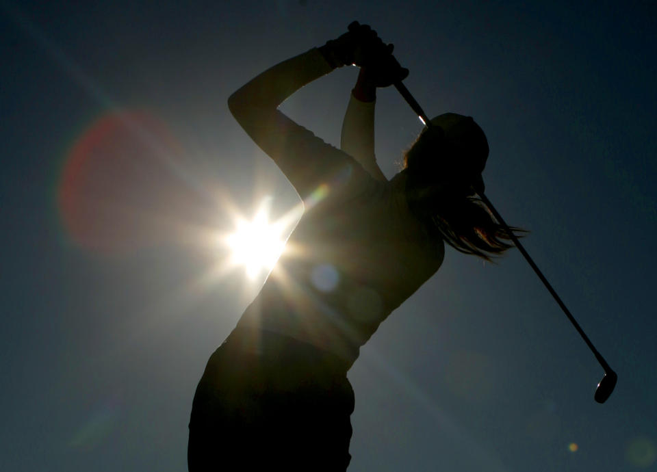 FILE - A golfer is silhouetted against the sun while teeing off on the third hole during the first round of the Women's British Open golf tournament at Royal Lytham and St Annes golf course in Lytham, north west England Thursday, Aug. 3, 2006. Kerry Bowie's daughters have dreams. Big ones. “There are some things people miss out on by not doing it,” Bowie says. “To be that young lady who plays golf, it changes things.” (AP Photo/Matt Dunham, File)