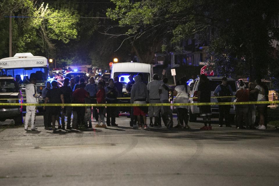 Family members of the victims and neighbors gather at the scene of a fatal shooting, Monday, June 21, 2021, in the Greater Ville neighborhood in north St. Louis. (Daniel Shular/St. Louis Post-Dispatch via AP)