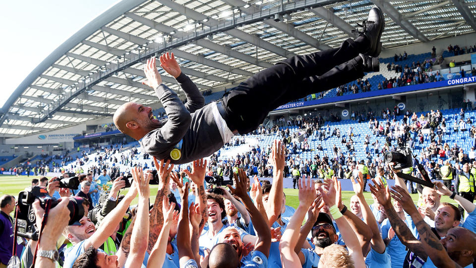 City manager Pep Guardiola is hoisted aloft by his victorious squad. Pic: Getty