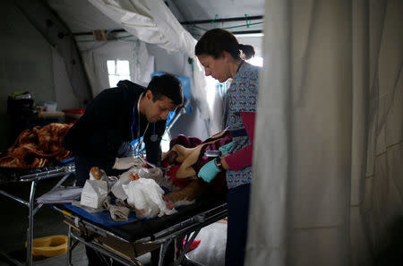 A wounded Iraqi receives treatment from foreign volunteer at the emergency field hospital run by the US Christian charity Samaritan's Purse, eastern Mosul, Iraq March 22, 2017. Picture taken March 22, 2017. REUTERS/Suhaib Salem