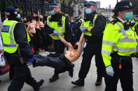 NOTE NUDITY Police detain a topless Extinction Rebellion protester outside the Houses of Parliament, London, on the last day of demonstrations.