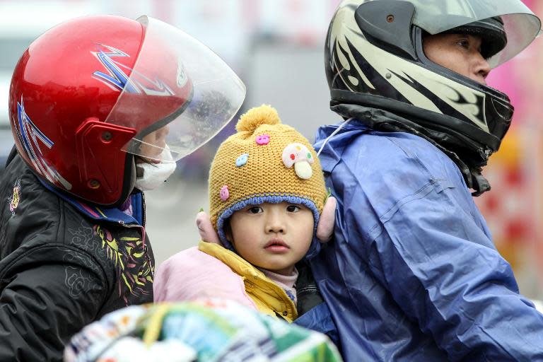 A Chinese family stop in Wuzhou, Guangxi province during their ride home, on January 25, 2014