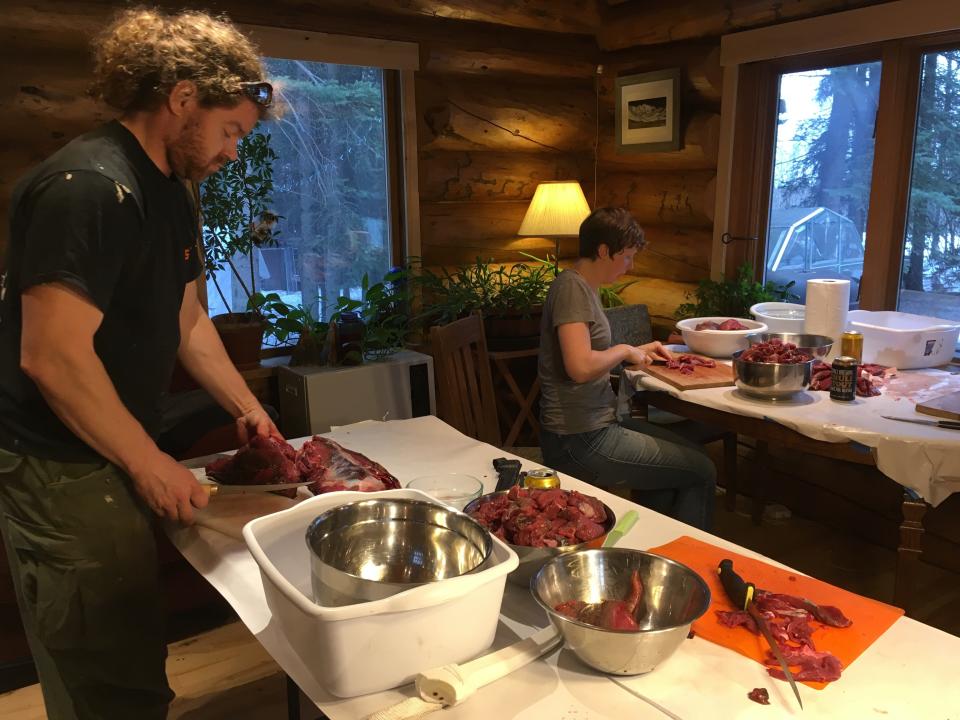 Joanna Young, who took this photo of friends Andrew Cyr (left) and Stephanie O’Daly harvesting roadkill moose meat, was a vegan when she moved to Alaska in 2010. Now Young eats roadkill meat regulary.