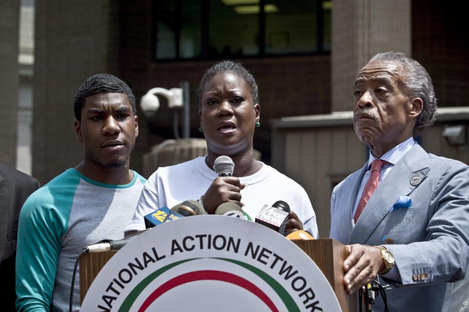 Trayvon Martin's mother, Sybrina Fulton, flanked by son Jahvaris and the Rev. Al Sharpton, addresses a rally in New York on July 20, 2013.