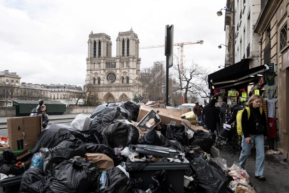 Cette photographie prise à Paris, le 13 mars 2023, montre des déchets ménagers près de la cathédrale Notre-Dame, qui s’entassent sur le trottoir alors que les éboueurs sont en grève depuis le 6 mars.