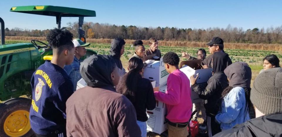 Reginald Cotten, farm manager and teacher, discusses the harvest with Halifax County Schools students at Greenleaf Farm. Courtesy of Halifax County Schools