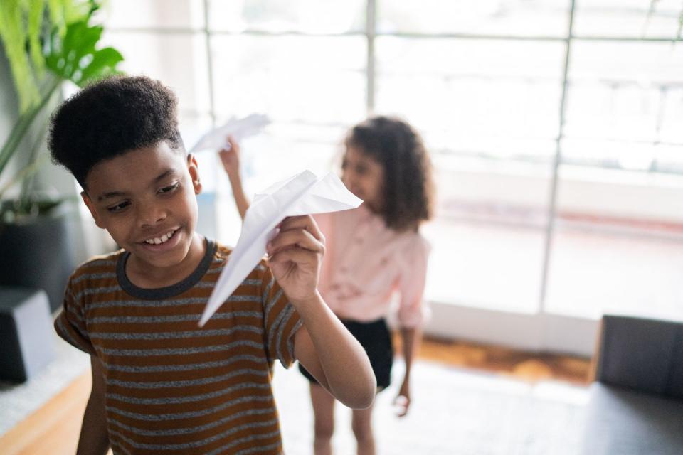 siblings playing with paper airplane at home fun activities for kids